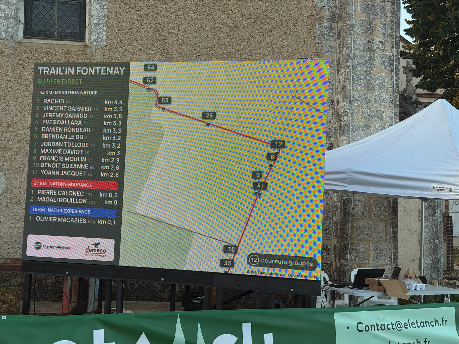 Écran LED du Trail'in Fontenay affichant la carte du parcours et le classement du 42 km en direct